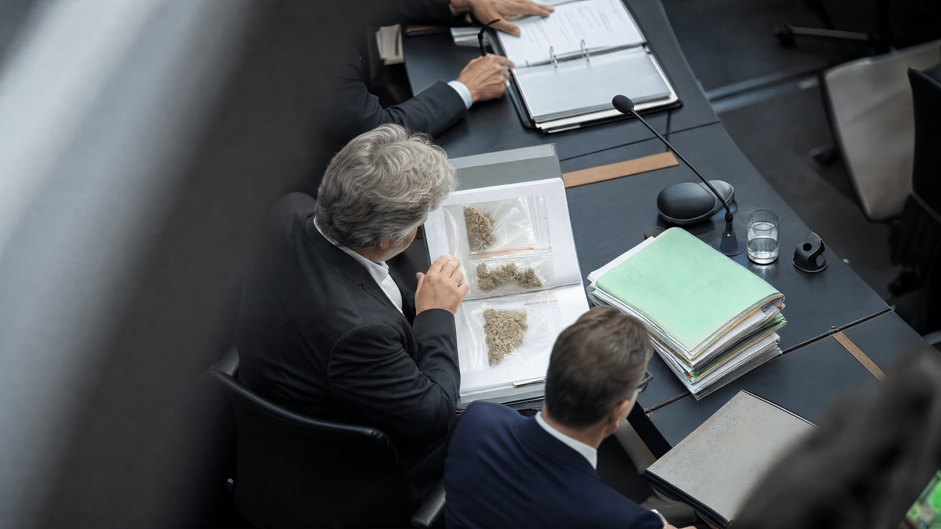 German Bundestag committee table with medical-cannabis reimbursement files and health-insurance folders